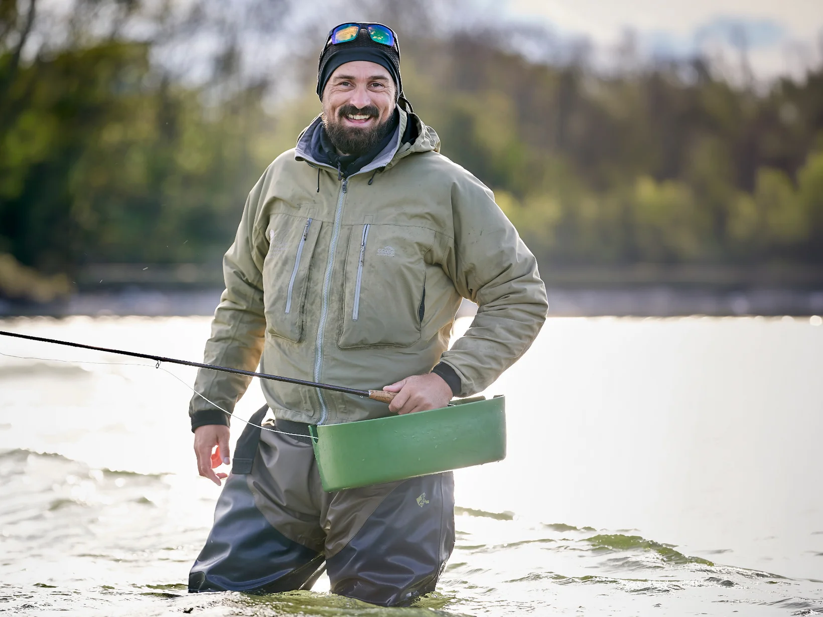 Foto von Alexander Seggelke mit einer Angel in der Hand im Wasser